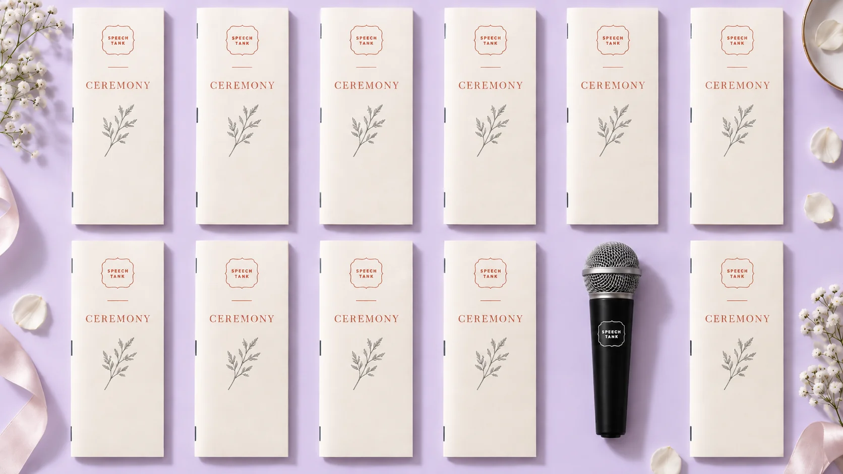 Wedding ceremony programs arranged beside a microphone on a lavender background
